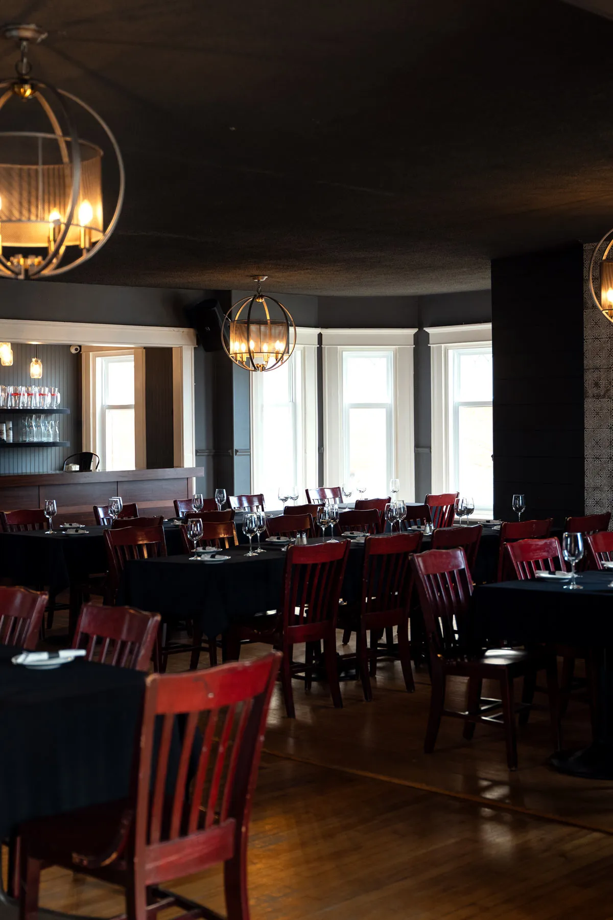 La salle du McBroue, maison centenaire de Valleyfield, tables dressées sous les lustres